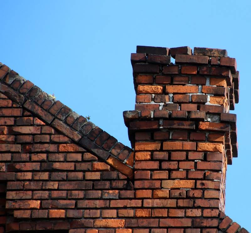 Damaged chimney on an Corona Del Mar home showing cracks and missing mortar